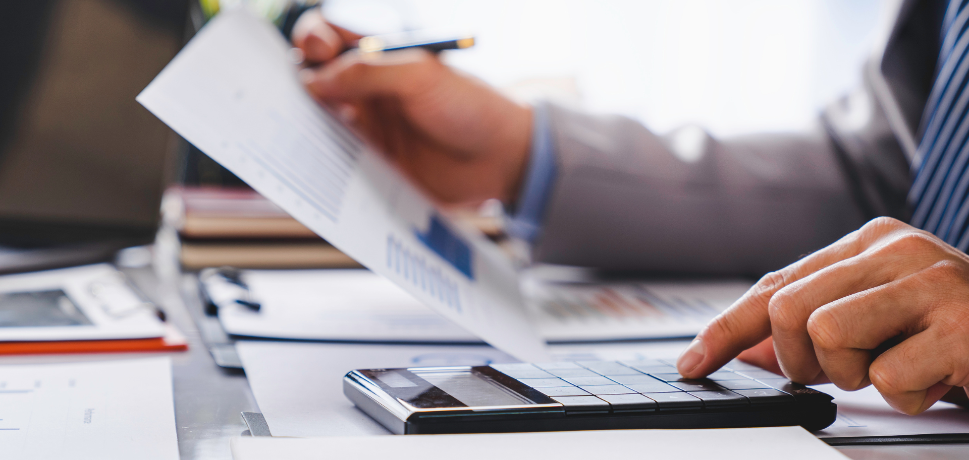 Advogado analisa documentos fiscais e relatórios financeiros, representando consultoria em IRS, IRC e IVA.