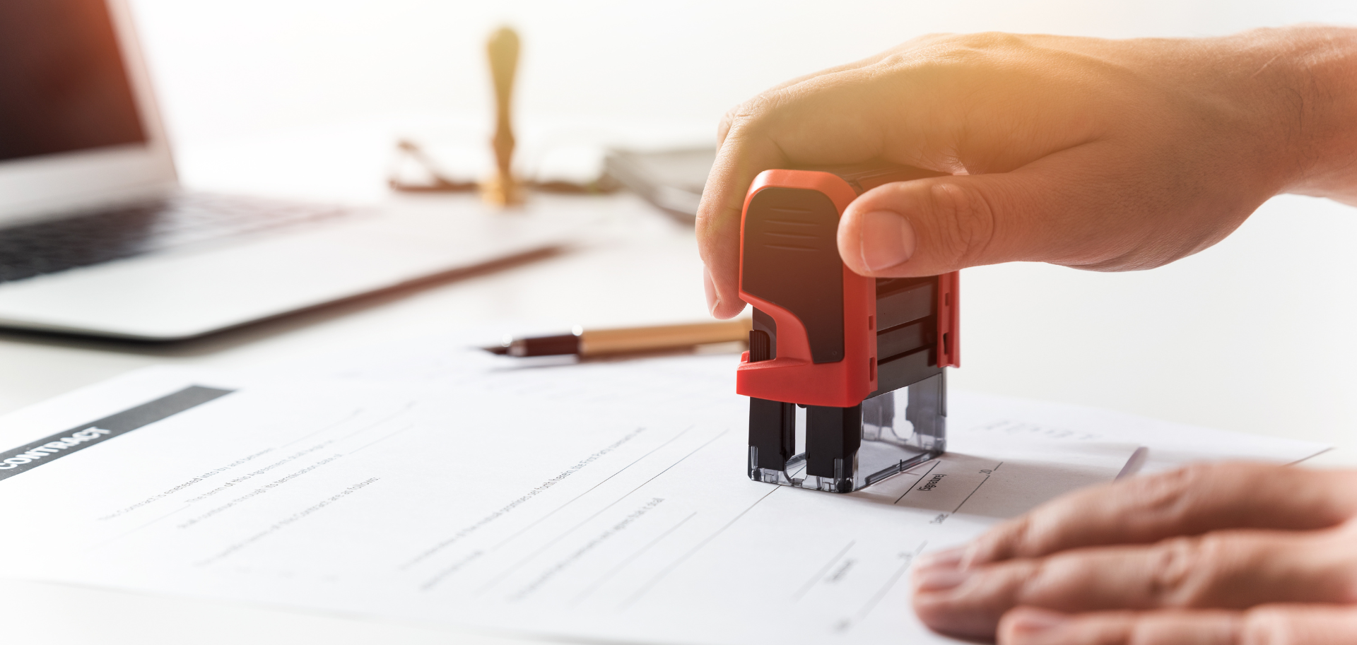 Advogado a carimbar documentos societários sobre alterações estatutárias de empresa, representando consultoria jurídica em Direito Comercial.