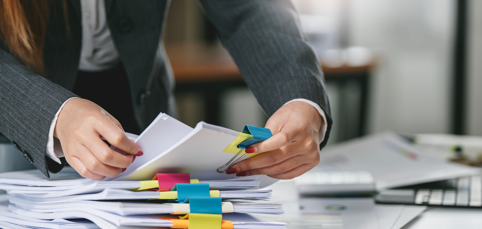Advogado analisa propostas e documentos de concursos públicos sobre uma mesa de escritório