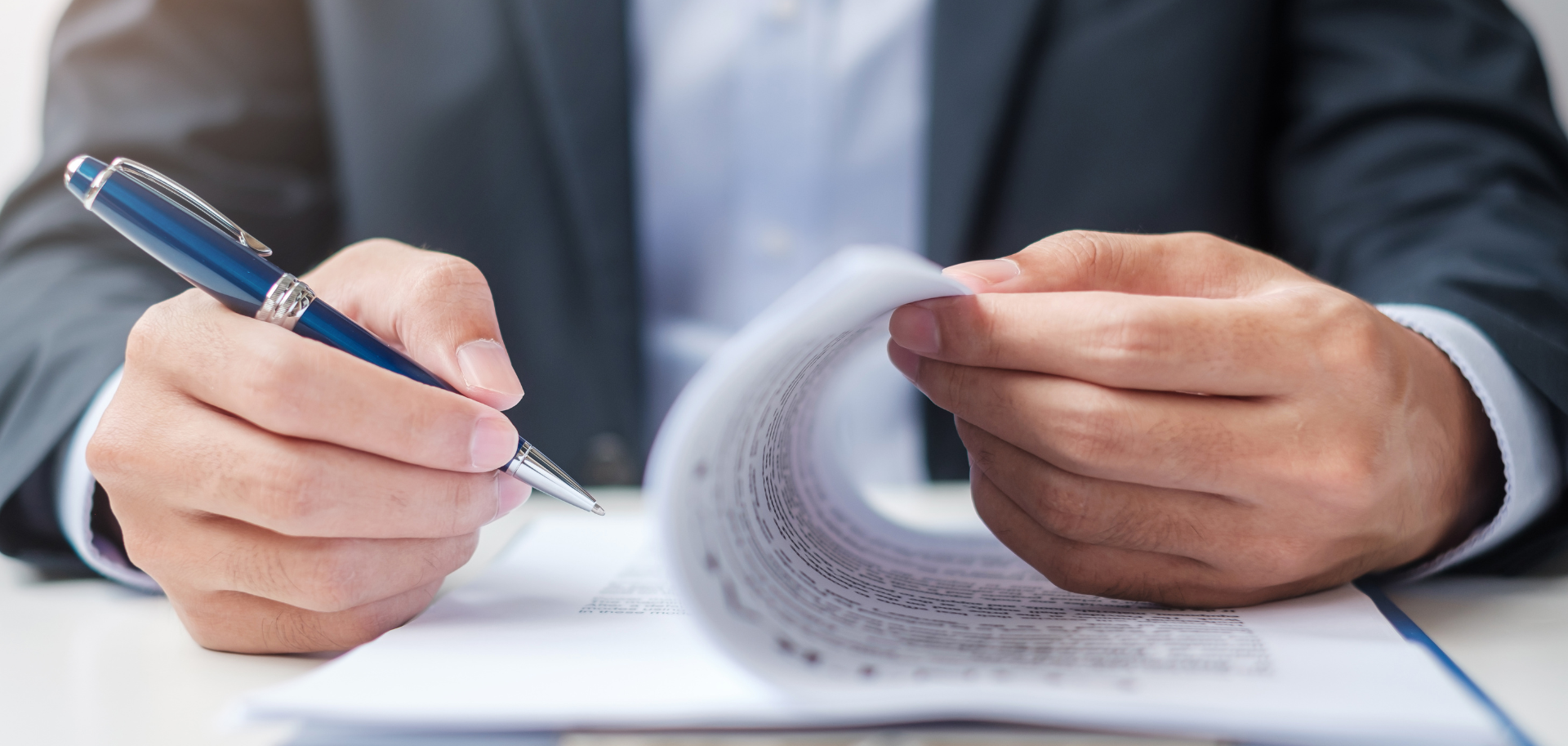 Advogado a rever e assinar contratos comerciais em mesa de escritório, representando consultoria jurídica online em Direito Comercial.