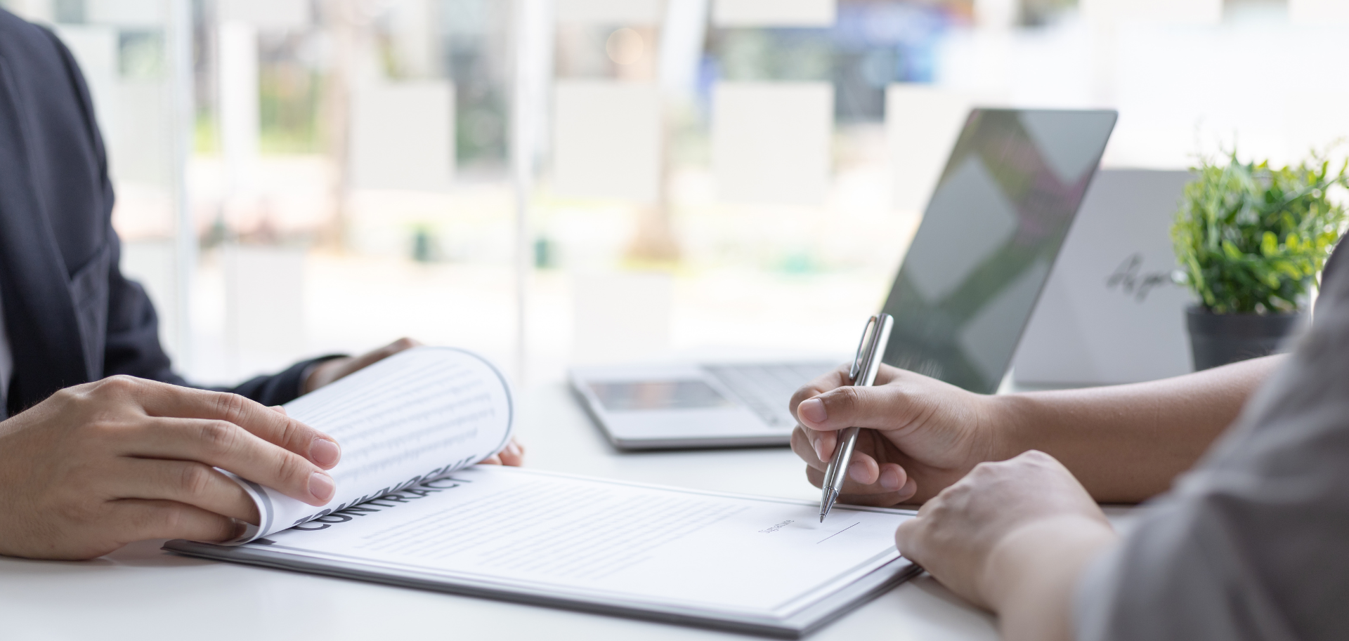 Mãos a rever e assinar um contrato de trabalho numa reunião